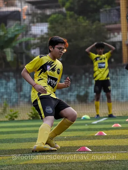 A player looks on during a drill, absorbing instructions and waiting for his turn. I foster an environment of active listening and learning.