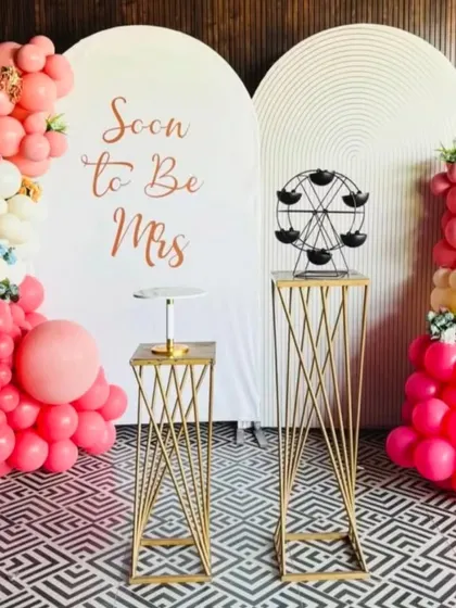 A beautiful setup for a bridal shower. The "Soon to Be Mrs" backdrop is paired with modern white panels, elegant props, and a lovely arrangement of pink and white balloons.