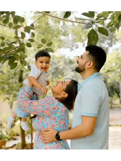 A moment of pure joy as mom lifts her son towards the sky, with dad looking on. This is what happy family memories are made of.