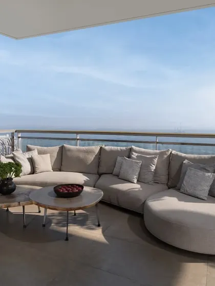 We believe in extending the living space outwards, blurring the lines between inside and out. This comfortable balcony seating area overlooks a stunning vista, creating a serene outdoor lounge that serves as a perfect urban retreat for quiet mornings or evening conversations.