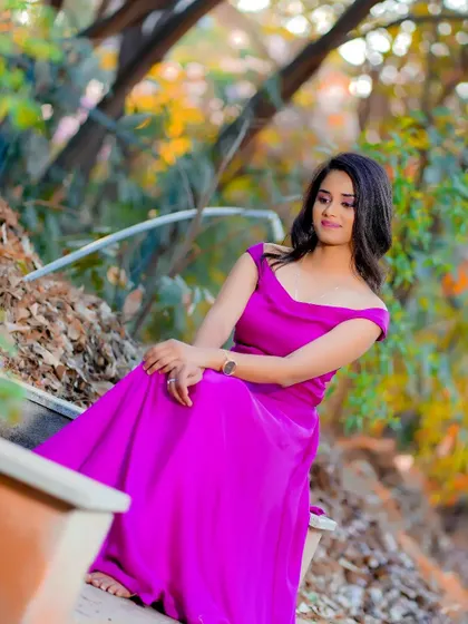 A serene moment captured during an outdoor shoot. The makeup is soft and pretty, enhancing her features as she enjoys a quiet moment in nature.