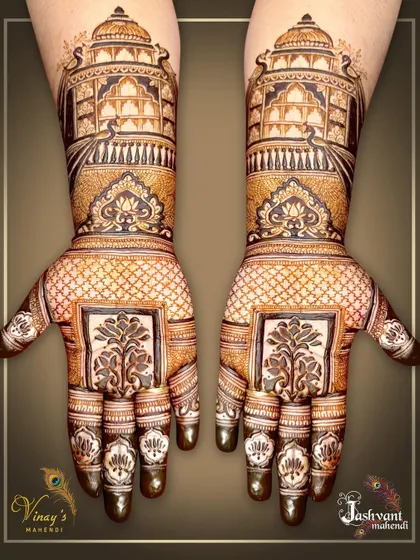 We bring the grandeur of Rajasthani palaces to your hands. This symmetrical design showcases magnificent jharokha architecture, filled with detailed lattice work and traditional motifs for a truly royal bridal look.