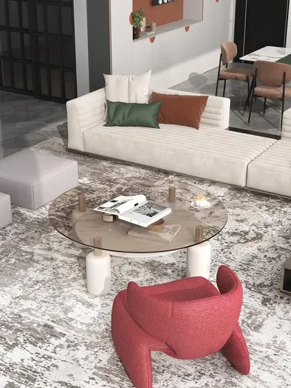 A close-up of the seating arrangement, highlighting the unique red accent chair that adds a playful yet chic element to the neutral palette.