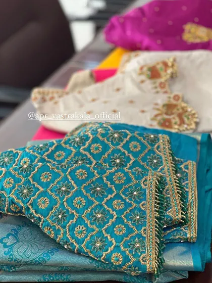 A collection of blouses, including the teal geometric design.