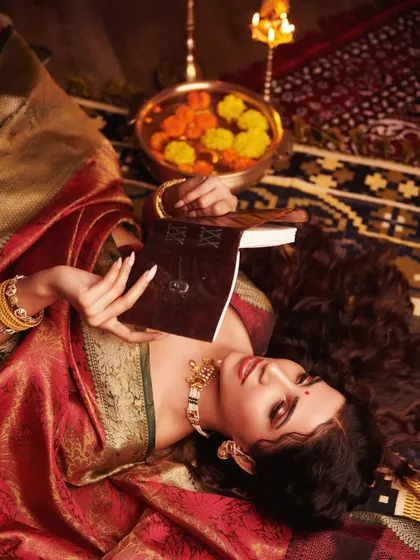A traditional bridal-inspired photoshoot. This look features dramatic eyes, a bold red lip, and glowing skin, perfect for a classic Indian bride.
