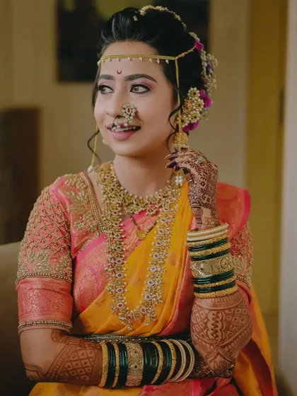 A close-up of the bride's happy expression, highlighting her beautiful smile and traditional bridal jewelry.