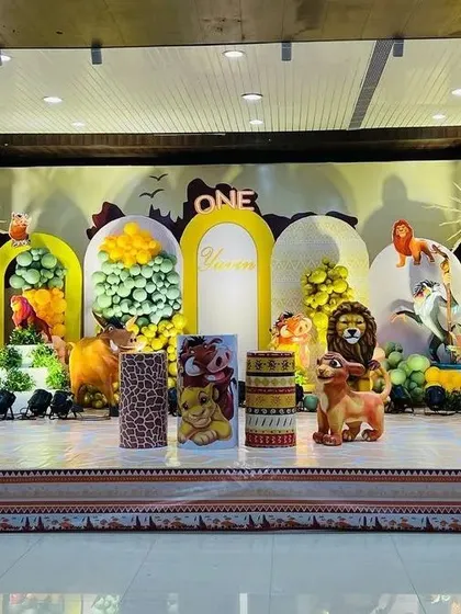 A grand Lion King themed first birthday party. The stage is filled with characters like Simba, Timon, and Pumbaa, with a 'Hakuna Matata' sign to complete the look.
