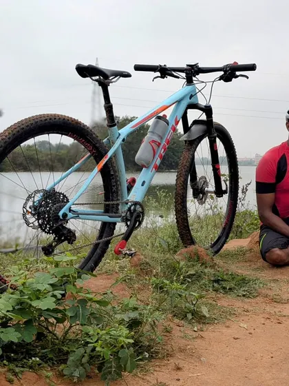 A moment of peace on a Sunday ride. A cyclist takes a break by the water, showcasing the beautiful outdoors we explore on our weekend group rides.