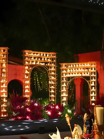 This nighttime ceremony backdrop features custom-built arches filled with hundreds of glowing candles. The design creates a warm, divine ambiance perfect for a sacred event.
