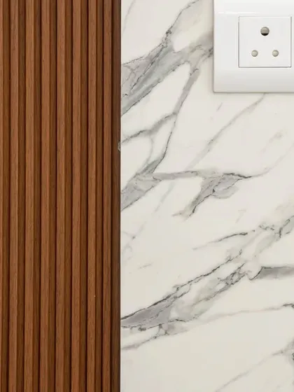 A closeup of the material palette, showing the combination of fluted wood panels and marble-finish laminate that we used to create a textured, luxurious feel in this Hyderabad home.