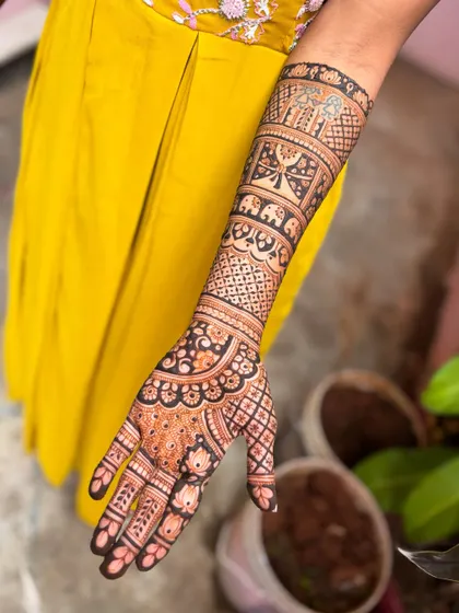A full-arm bridal design for Kavitha, featuring intricate patterns and personalized elements.
