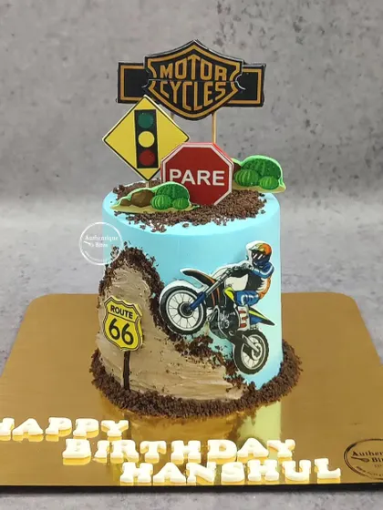 A dirt bike-themed cake for an adventurous birthday. The design features a biker on a dirt track with road signs.