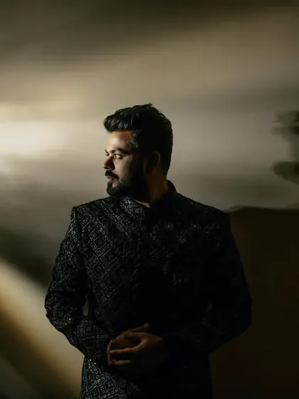 A dramatic groom portrait with creative lighting that casts beautiful, textured shadows. This style of photography highlights a sense of mystery and sophistication.