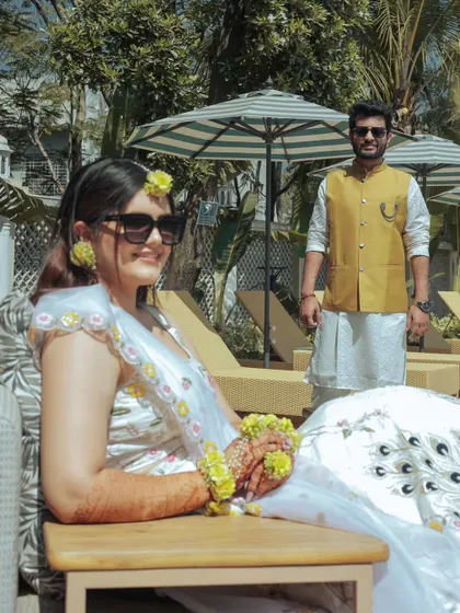A chic and relaxed portrait from a poolside Haldi or pre-wedding event. The bride-to-be looks effortlessly cool, showcasing a modern take on wedding festivities.
