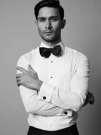 A sharp and classic formal portrait for an actor. The crisp white shirt and bow tie, rendered in black and white, create a timeless and sophisticated headshot.