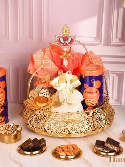 Celebrate health and luxury with the Abhushan Hamper. This golden basket is filled with cookies, nuts, and sugar-free bars, complete with a 'Shubh Labh' diya for a thoughtful festive touch.
