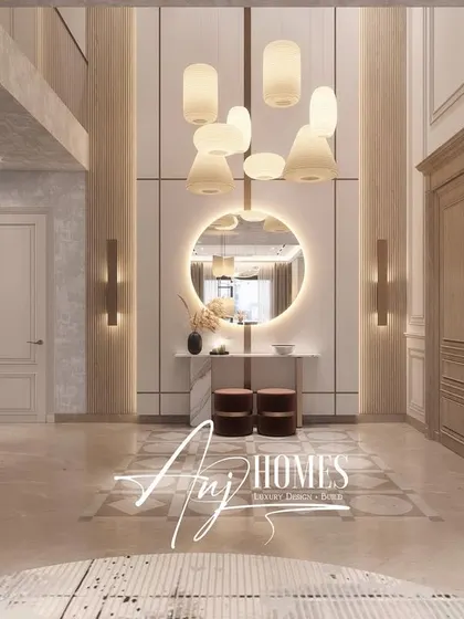 This double-height lobby design creates a grand first impression. A statement chandelier, a large circular mirror, and a classical sculpture are used to create a space that feels both sophisticated and welcoming.