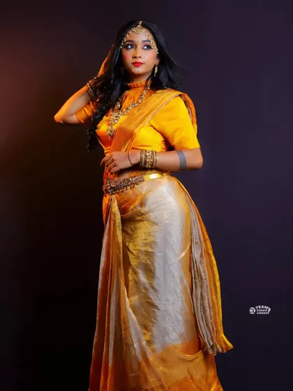 A full-length shot of a different styling for a yellow tissue silk half saree, showing its versatility.