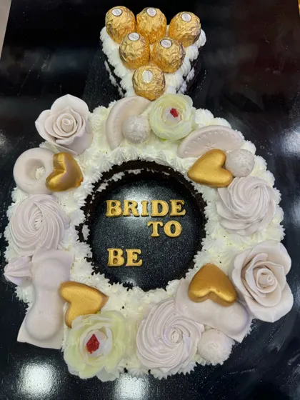 Another view of the beautiful ring-shaped "Bride to Be" cake. The intricate details of the floral piping and golden hearts make this a truly special and memorable cake for the celebration.