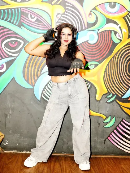 Ready to play, standing against a vibrant graffiti wall. This look, with the crop top and cargo pants, is all about urban energy and the soul of the music.