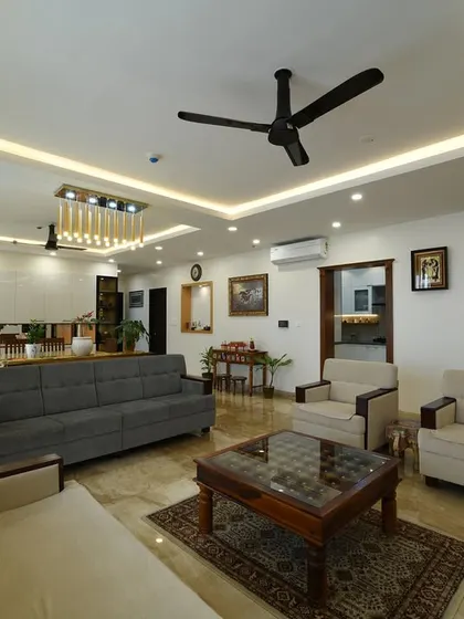 This wide-angle shot shows the grandeur of an open-plan living and dining area. The consistent flooring and ceiling design tie the large space together, while distinct furniture groupings define each zone.