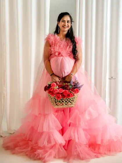 The full view of this pink tiered maternity gown shows its beautiful layers. It's a perfect choice for clients who want a grand, princess-style photoshoot.