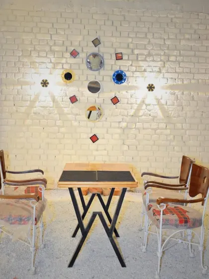 A quirky and artistic seating area against a white brick wall.