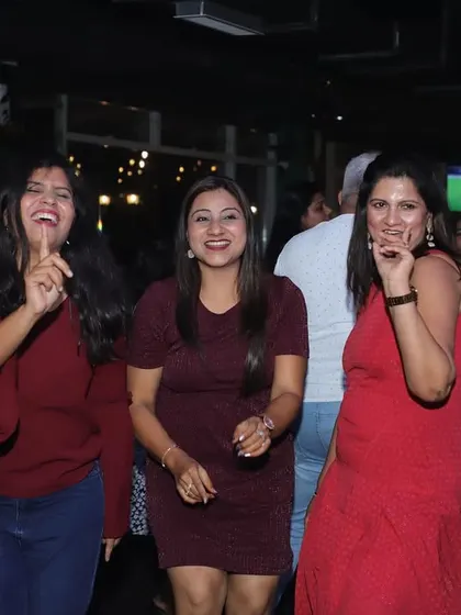 Three friends laughing and dancing together. The genuine joy and camaraderie are what make the parties here so special.