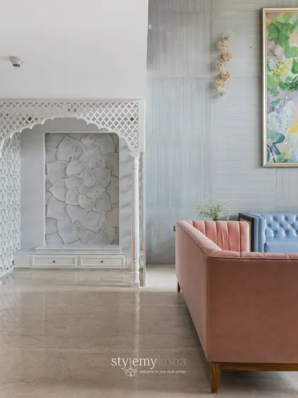 This view shows the beautiful harmony between the traditional marble mandir and the modern, colorful furniture in the living area. It’s a perfect example of blending different styles seamlessly.