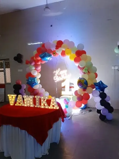 This setup for Vamika's first birthday shows how we can arrange our decor in a larger hall, including a dedicated cake table.