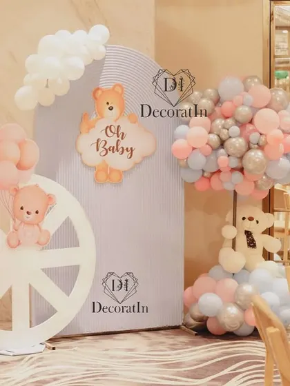 A photo corner with a wheel prop and "Oh Baby" signs, decorated in a soft pastel palette.