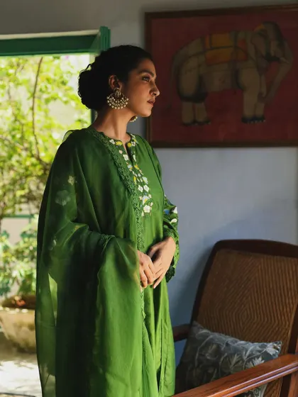 A serene portrait for Baavli, with the model in a beautiful green outfit, framed by a window with soft natural light.