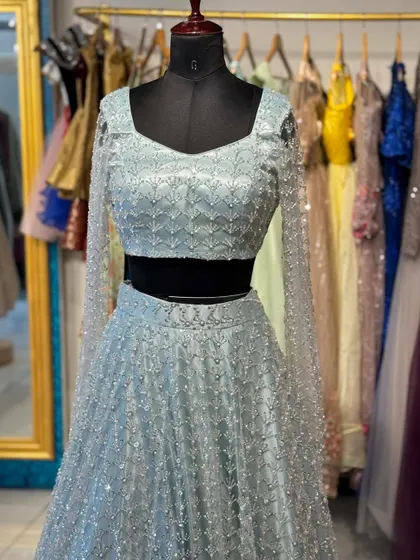 A dreamy powder blue lehenga with all-over silver sequin work and sheer embroidered sleeves. Perfect for a modern fairytale look.