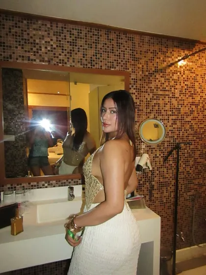 Another angle of the golden sequin top and white pants outfit.