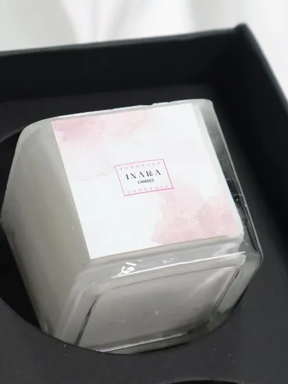 This white candle, part of a curated gift set, offers a clean and classic look. The minimalist label and clear glass jar make it a versatile choice for any decor.