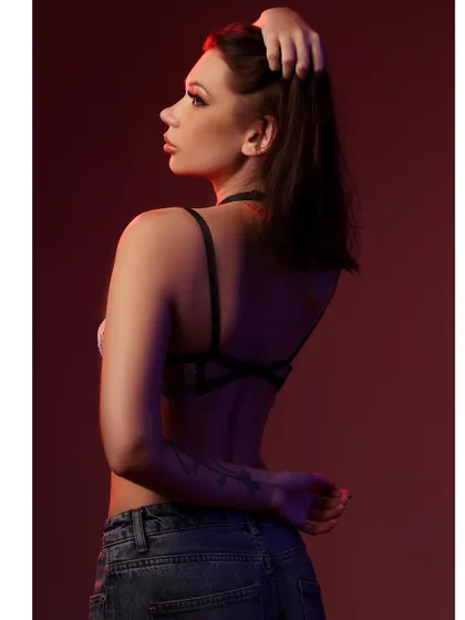 A portrait that plays with light and shadow, using a red gel to create a moody and intense atmosphere. The model's pose and expression are highlighted by the selective lighting.