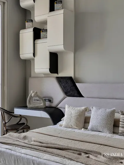 This monochrome bedroom proves that contrast is key to creating a calm yet dynamic space. The sculptural black and white shelving unit acts as both a study desk and a headboard, blending bold design with function.