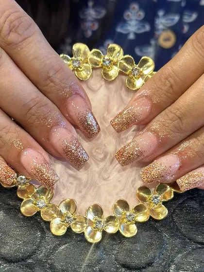 A warm and sparkling set of square-shaped extensions with a bronze glitter ombre effect.