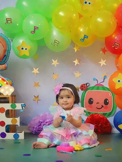 All smiles in her Cocomelon wonderland. The bright colors, balloons, and characters make this theme a huge hit with the little ones.
