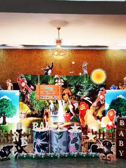 An elaborate jungle scene with a waterfall backdrop and numerous animal cutouts. This decoration creates a dense and immersive environment for a truly wild birthday party.