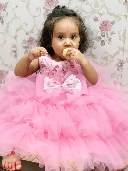 My little one enjoying a treat during Diwali, looking like a princess in her pink dress. It's the small, happy moments that make the best memories.