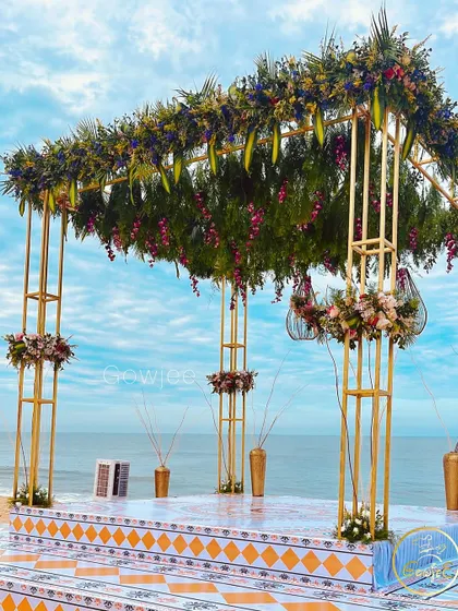 Another view of the stunning beachside wedding mandap, highlighting the contrast between the floral decor and the sea.