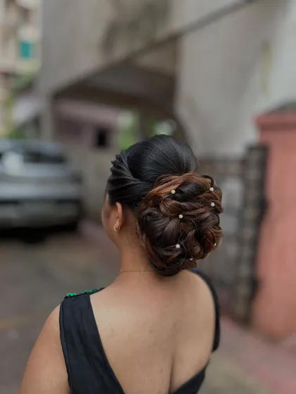 A classic low bun with a modern twist. The bun is decorated with delicate pearls for an elegant and sophisticated party look.