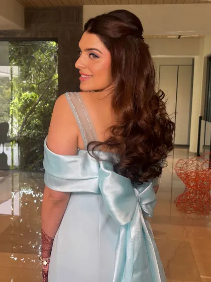 A side view of the engagement hairstyle, showing the soft volume at the crown and the beautiful curls. The style perfectly complements her off-the-shoulder gown.