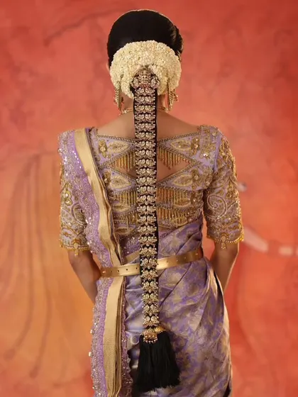 The back view of the ensemble, highlighting the detailed geometric embroidery on the blouse that complements the traditional hairstyle.