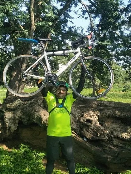 That feeling of accomplishment after conquering a tough section of the trail. This rider is celebrating with his Btwin road bike held high.