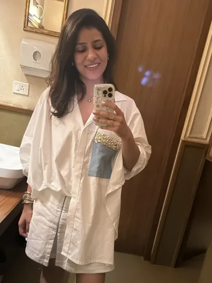 A bathroom selfie showing off my oversized white shirt with an embellished pocket. It's a versatile piece that I wore multiple times during my Goa trip, styled in different ways.