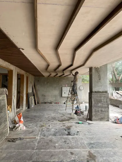 Even functional areas like the parking garage deserve attention. Here, a worker is installing a custom wooden ceiling, adding a touch of warmth and design from the moment you arrive home.