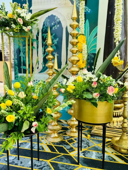 The vibrant colors and traditional elements of our Haldi decor, showing how we combine flowers, brass, and custom art to create a unique setting.