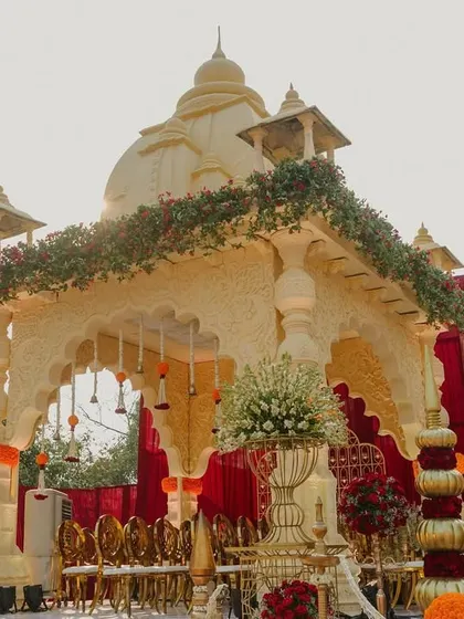 A temple-style mandap structure, intricately carved and adorned with floral garlands. This design is perfect for couples seeking a deeply traditional and spiritual wedding ceremony.